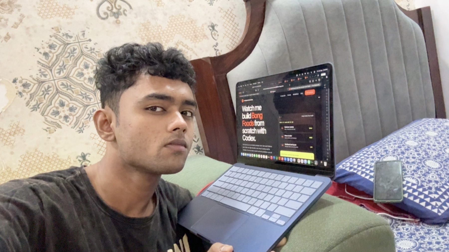 Sohan Vyaparee holding a laptop showing the Bong Foods live masterclass website